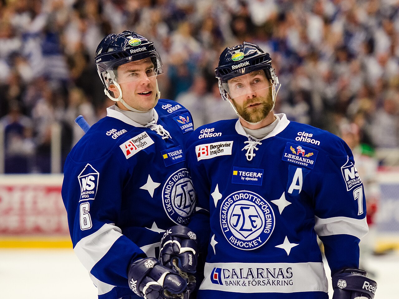 Två lagkamrater på isen under en ishockeymatch
